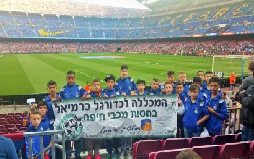 קבוצה אורחת עם הדגל שלה ביציעים של קאמפ נואו